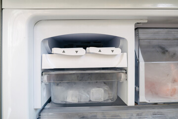 Fototapeta premium Ice maker and tray in the refrigerator