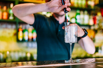 man hand bartender making cocktail in glass on the bar counter