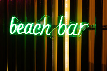 Neon signboard beach bar close-up.