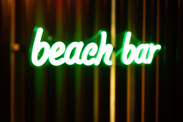 Blurred photo of a neon signboard of a beach bar.