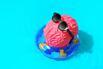 Human Brain Character in Sunglasses Floating in a Pool Ring