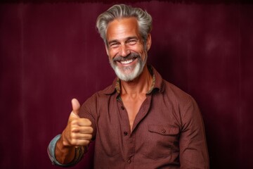 Lifestyle portrait photography of a joyful mature man showing a thumb up against a rich maroon background. With generative AI technology