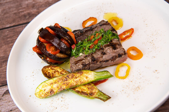 Recipe for grilled steak with chimichurri sauce, accompanied by a farandole of vegetables. High quality photo