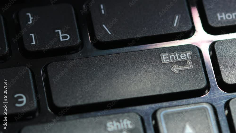 Poster finger presses enter button on laptop keyboard.