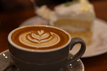 Close up a cup of hot latte art coffee on wooden table.A cappuccino is an espresso-based coffee drink with steamed milk foam.Best of menu in the coffee shop or restaurant.