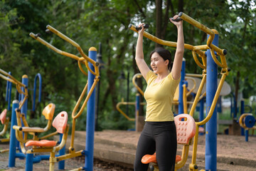 Fototapeta na wymiar Asian women exercise using amusement facilities in parks. The concept of healthy exercise and taking care of themselves