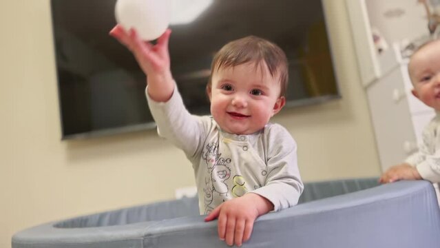 group of baby playing. happy family kid dream concept. two babies are playing in a dry pool throwing plastic balls. game baby family play dabble throw balls lifestyle