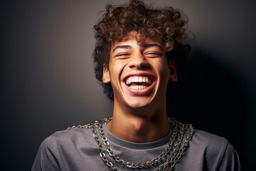 Lifestyle portrait photography of a grinning boy in his 20s smiling and showing the brackets of her...