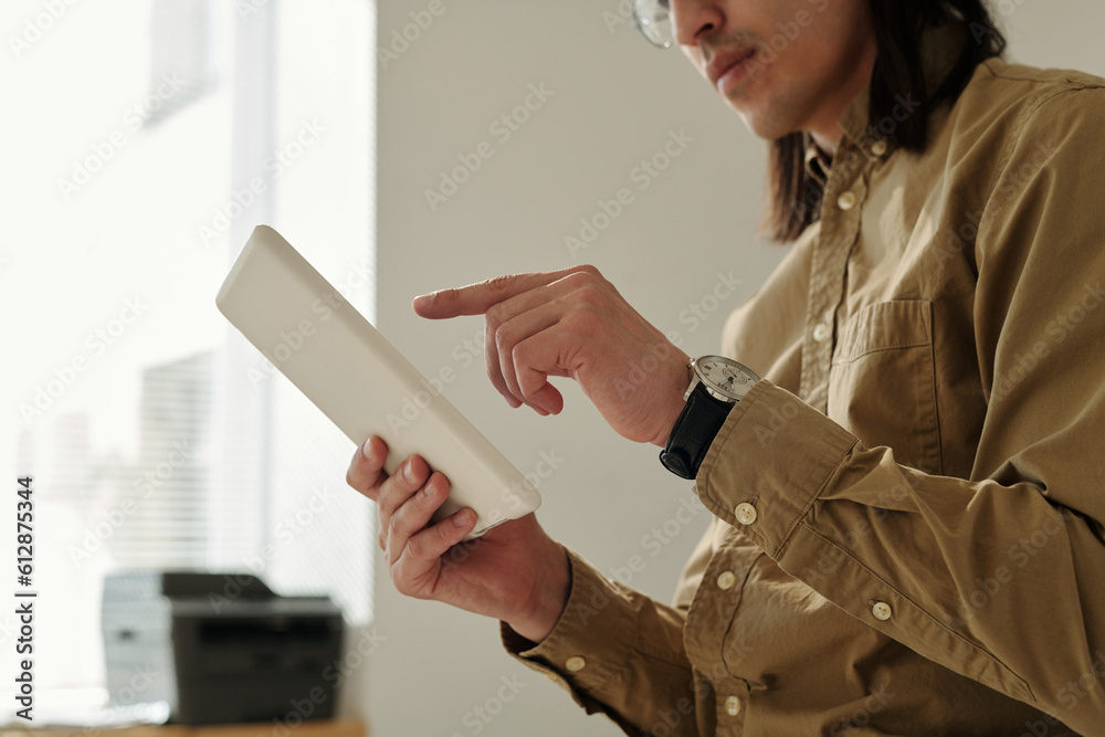 Poster hand of young male manager pointing at tablet screen during presentation or while analyzing online f