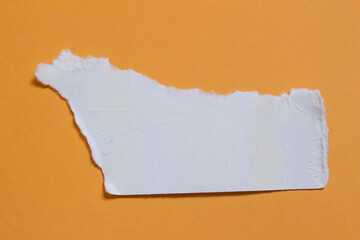 Torn cardboard piece on orange background