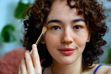 closeup woman applying makeup at home with brush