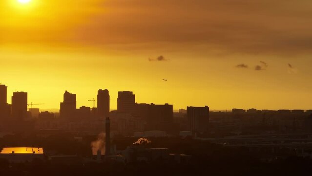 Aerial view of passenger jet plane taking off above downtown district of Tampa city in Florida, USA at sunset. Dark silhouette of high skyscraper office buildings in modern american midtown