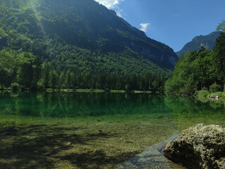 Bluntausee, Salzburger land, Austria. Mountain lake. Alps. Blue crystal clear water. Summer rocky landscape. Hiking place. Green landscape. Trees. Lake coastline.