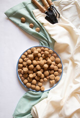 Edible Caramel Clay Stones in a round plate, with two garden shovels, a mini wrack minimal flat lay.