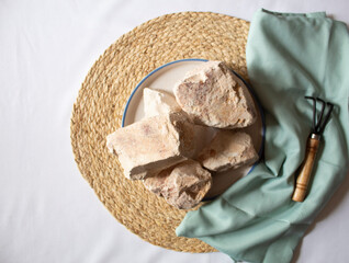 Edible White Clay Stones in a round plate, with a small garden wrack minimal flat lay