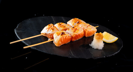 japanese food, salmon grill in an Asian restaurant, salmon grill with black background. Japanse cuisine. A variety of Japanese food