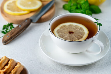 Tea with lemon in a white mug on the table