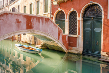 Boat under the stone bridge in beautiful lighting in Venice, Italy, Europe