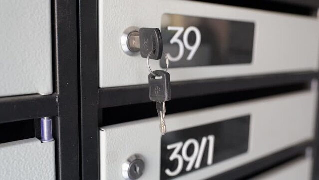 Steel mailboxes in an apartment residential building with two swaying keys. Numbered mailboxes for letters, newspapers, receipts and miscellaneous correspondence. Key with private mailbox at the condo
