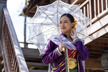 Asian beautiful lady wear a luxury national dress holding a white umbrella while standing on the...