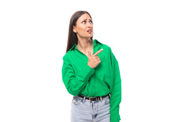 brown-eyed brunette young business lady in a green shirt shows her hand to the side on a white background with copy space