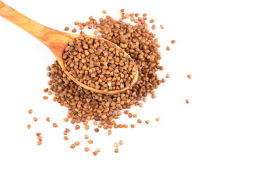Uncooked buckwheat on wooden spoon