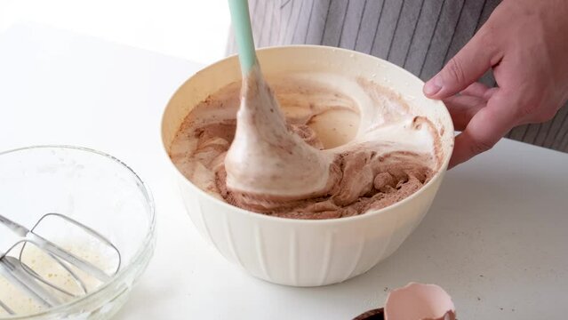 closeup of hand mixing dought for cake with spatula, slow motion