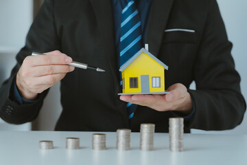house model ,The hand of the businessman guarding close Money saving ideas to buy a home or loan for real estate investment planning and ideas during saving can be risky.