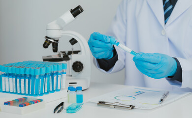 Close up view of scientist analyzing a liquid in the test tubes in laboratory.