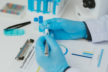 Close up view of scientist analyzing a liquid in the test tubes in laboratory.