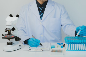 Fototapeta premium Close up view of scientist analyzing a liquid in the test tubes in laboratory.
