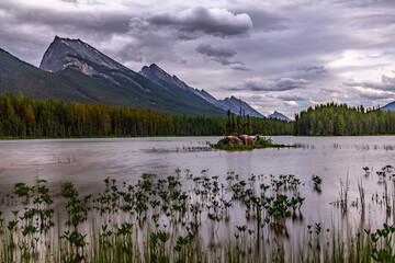 Diagonally sloping mountain range rising from a wooded lake with a rocky island, Honeymoon Lake,...