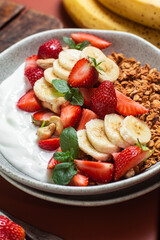 Granola with yogurt, strawberry and banana in a bowl