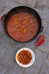 Chili con Carne in the dutch oven with red hot peppers. 