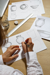 The designer draws sketches of kitchen utensils. Dishes design.