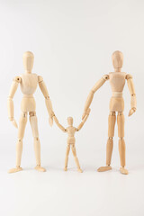Family of wooden puppets with the kid on white background.