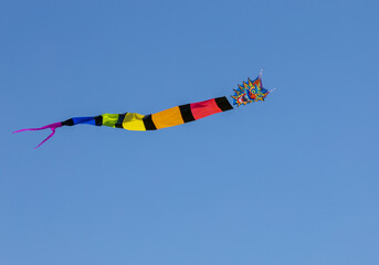 A colorful kite floating in the sky. A kite with blue sky background