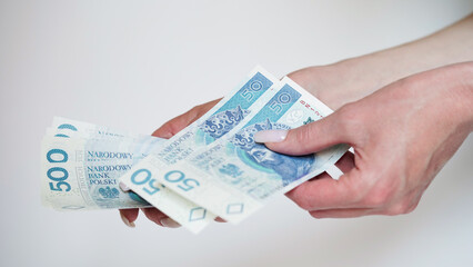 Close-up of female hands counting money,salary in zlotys,Polish currency.Concept of currency exchange in another country.Inflation and taxes in European Union.Payment for purchases.Copy space.