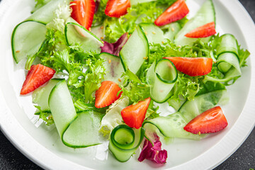 fresh salad strawberry cucumber, lettuce diet meal food snack on the table copy space food background rustic top view 