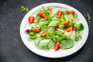 fresh salad strawberry cucumber, lettuce diet meal food snack on the table copy space food background rustic top view 