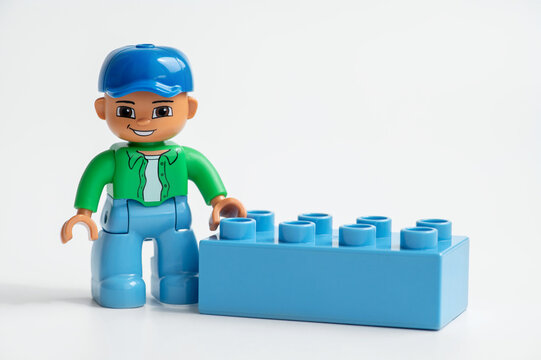 Lego man from Lego Duplo and blue Lego brick on a white background