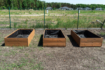 Ready wooden boxes for vegetables lined with agrotextile from the inside.