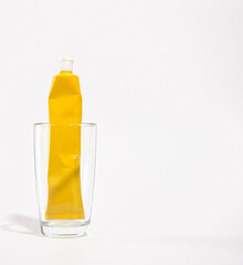Yellow tube of refreshing and whitening toothpaste in glass cup. Copy space for text. Oral dental hygiene.