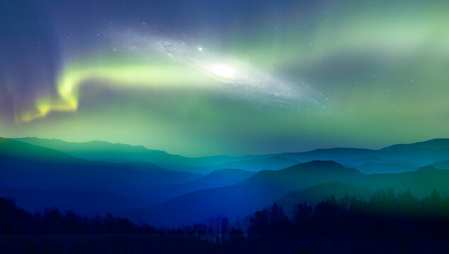 Beautiful landscape with blue misty silhouettes of mountains - Northern lights (Aurora borealis) over the mountains with Andromeda Galaxy - "Elements of this image furnished by NASA"