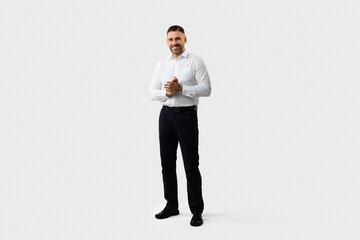 Full body length shot of handsome middle aged man entrepreneur in suit standing posing over light grey studio background
