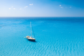 Obraz premium Drone view of a sailing yacht. Luxury transportation. Vacationing people. Vacation and holidays. Summer time for sea travel. The sea bay. Photo for background and wallpaper. Mediterranean Sea.