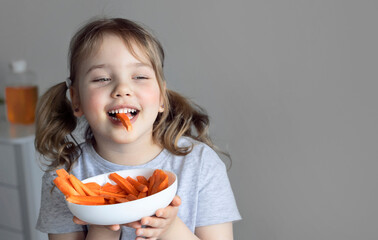 Child eating carrots empty copy space.Caucasian girl healthy lifestyle concept. Toddler's nutrition. Kid eats vegetables.