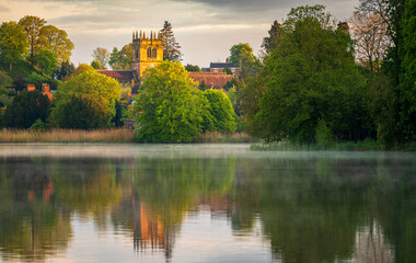 Fototapeta na wymiar Sunset view of town of Ellesmere in Shropshire with reflection view across the Mere to the Church
