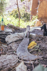 machete with a curved blade, on the rock in the shade, hard work, village, work on the land, clearing bushes, outgrown vegetation 