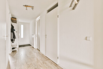 a long hallway with white walls and wood flooring the room is clean and ready for guests to walk in